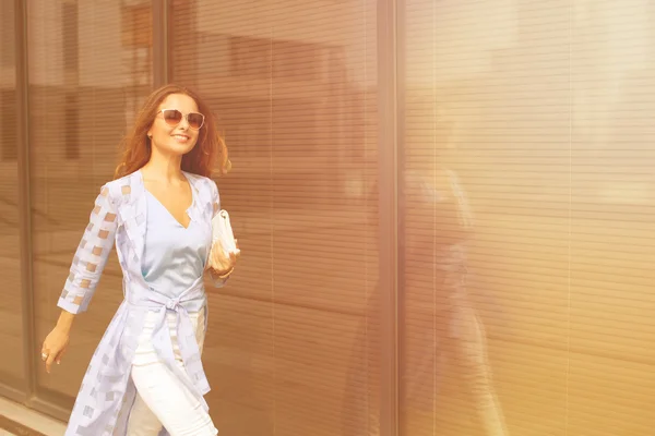 Mujer de negocios caminando cerca de edificio de oficinas — Foto de Stock