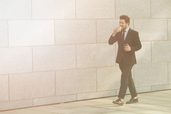 Businessman eating and drinking on to go — Stock Photo, Image