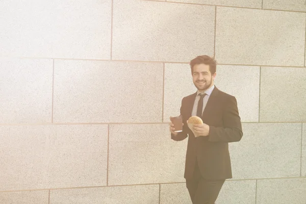 Businessman eating and drinking on to go — Stock Photo, Image