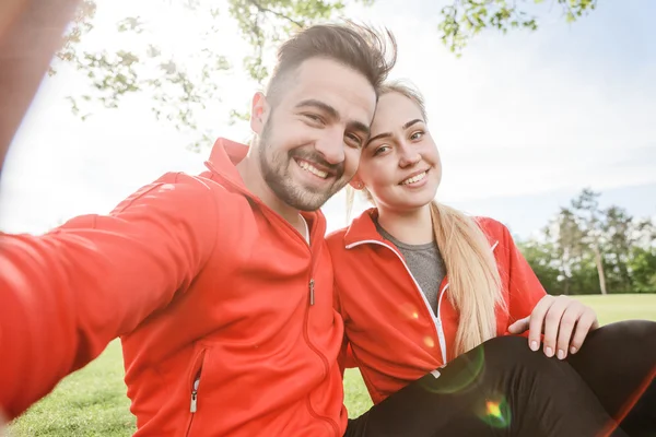 Sport man en vrouw voor het maken van selfies in park — Stockfoto