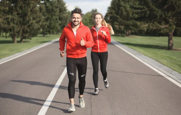 Sport man en vrouw joggen in het park — Stockfoto