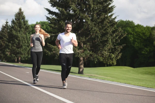 Sport man en vrouw joggen in het park — Stockfoto