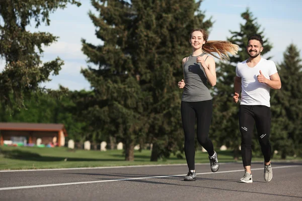 Sport man en vrouw joggen in het park — Stockfoto