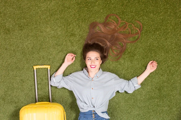 Mooie toeristische dame liggend op groen gras — Stockfoto