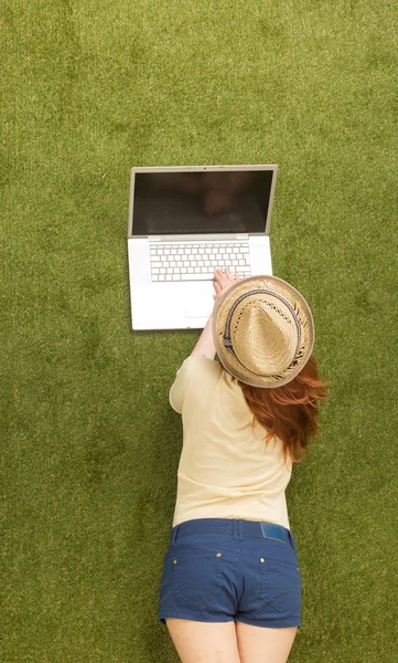 Woman on grass with laptop computer — Stok fotoğraf