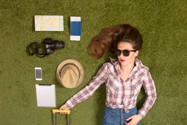 Beautiful tourist lady lying on green grass — Stock Photo, Image