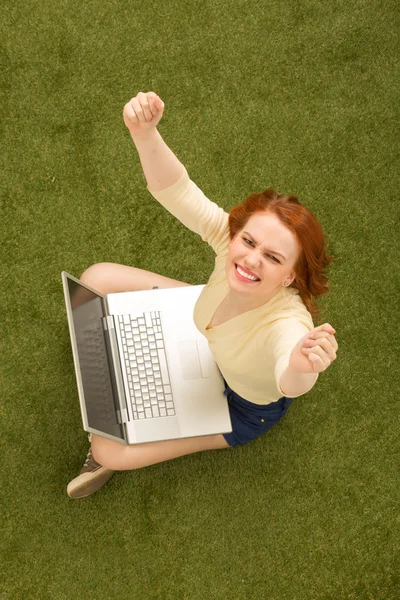 Woman on grass with laptop computer — Stok fotoğraf