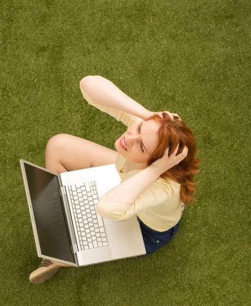 Woman on grass with laptop computer — Zdjęcie stockowe