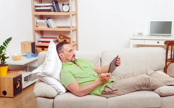 Knappe man rustend op de sofa thuis — Stockfoto