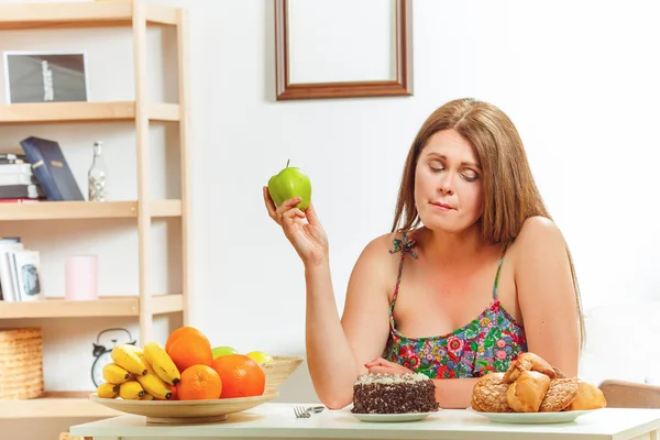 Fat woman sitting at table home — Stock Photo, Image