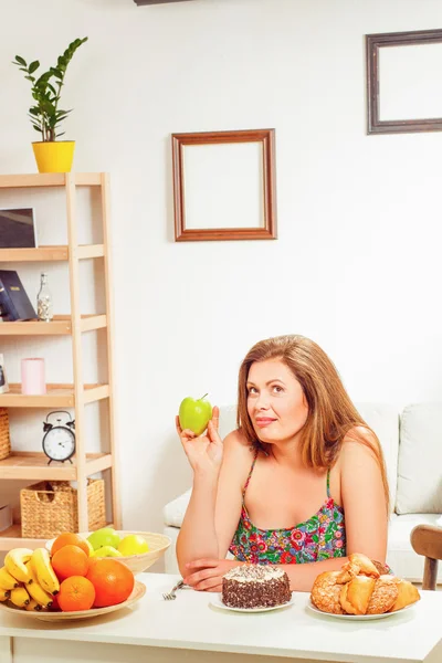 Mujer gorda sentada a la mesa en casa — Foto de Stock