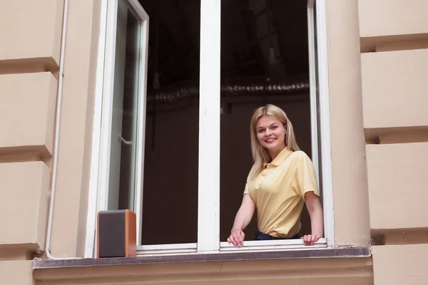 Señora feliz mirando desde la ventana — Foto de Stock