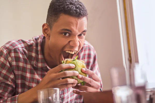 Pria yang makan burger vegan di restoran — Stok Foto