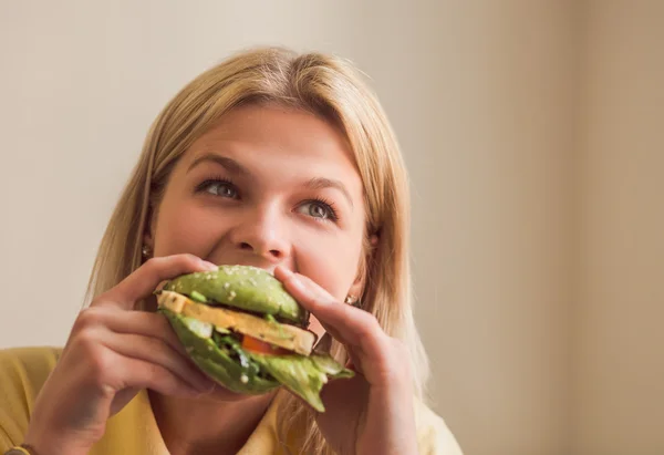 Mujer comiendo hamburguesa vegana en el restaurante — Foto de Stock