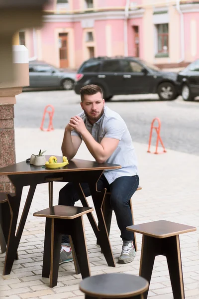 Bonito homem sentado no café vegan ao ar livre — Fotografia de Stock