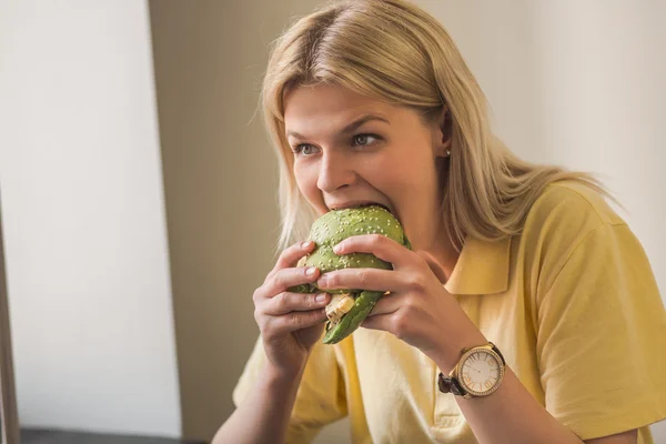 Woman eating vegan burger in restaurant — Stock Photo, Image