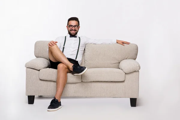 Sorrindo homem bonito sentado no sofá — Fotografia de Stock