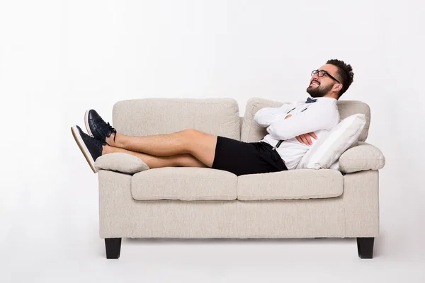 Sonriente hombre guapo acostado en el sofá — Foto de Stock