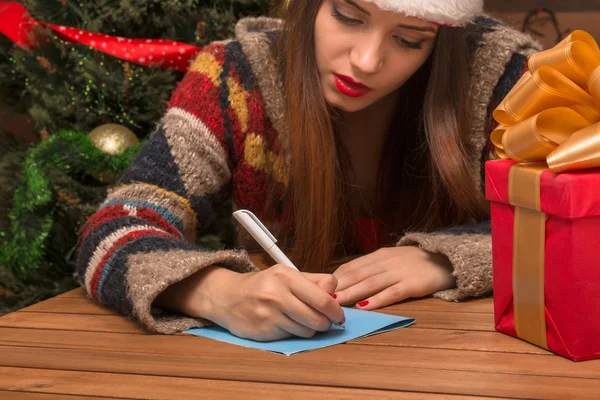 Beautiful girl writing New Year and Christmas congratulation — Stock Photo, Image