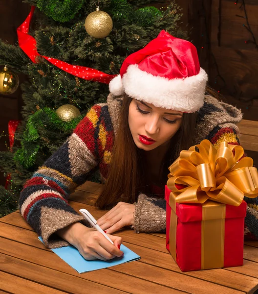 Beautiful girl writing New Year and Christmas congratulation — Stock Photo, Image