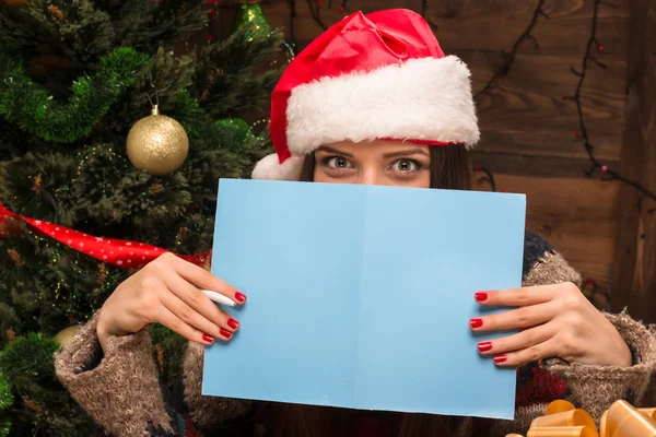 Beautiful girl holding a New Year and Christmas post card — Stock Photo, Image