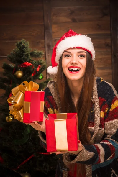 Beautiful girl opening a present near New Year tree — Stock Photo, Image