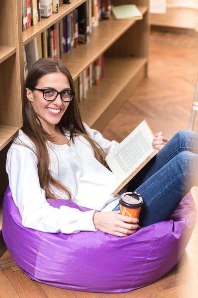 Beautiful lady reading book in library — Stock Photo, Image