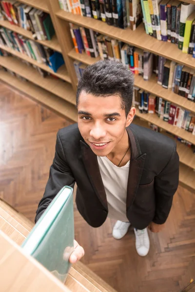 Hombre guapo tomando un libro en la biblioteca —  Fotos de Stock