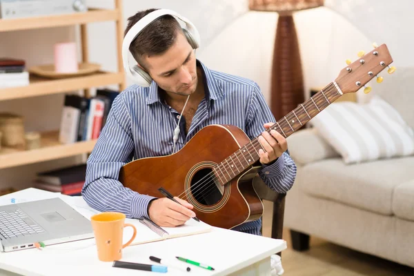 Όμορφος άντρας παίζει κιθάρα στο σπίτι. — Φωτογραφία Αρχείου