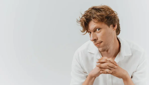 Shaggy man looks expressively into camera crossed fingers. Hairstyle concept. Cut out on white background with copy space — Stock Photo, Image