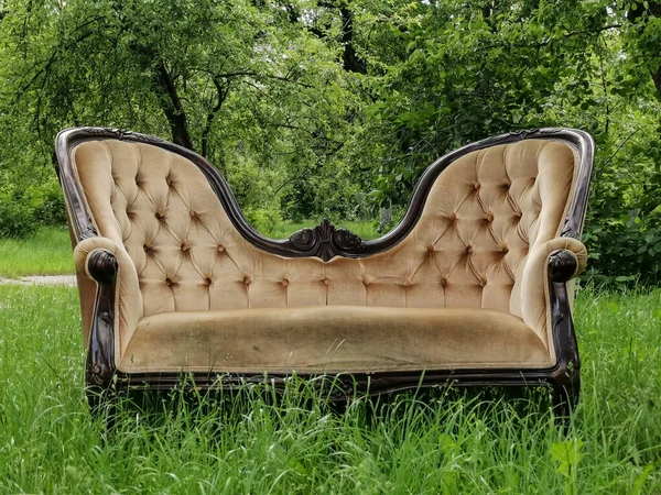 Lyxig vintage soffa på grönt gräs i trädgården. Det är vår. Framifrån — Stockfoto