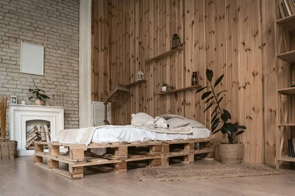 Interior acolhedor quarto com lareira branca. Paredes com painéis de madeira e tijolos — Fotografia de Stock