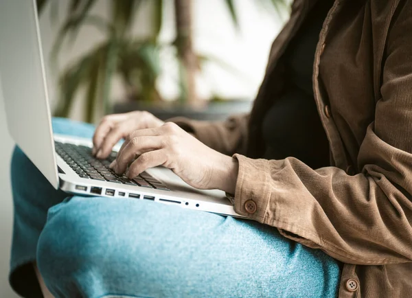 Freelancer vrouw werkt met laptop computer met behulp van internet tijdens het zitten op vensterbank. Dichtbij schot. Levensstijl concept — Stockfoto