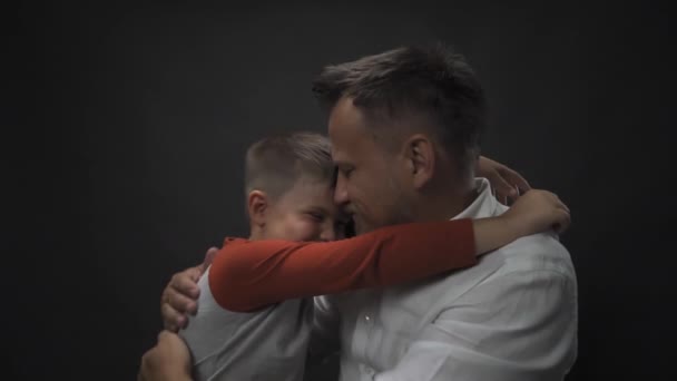 Ο πατέρας αγκαλιάζεται με το γιο του σε ένα στούντιο αργής κίνησης. Χέρια του πατέρα και του γιου σε ένα απομονωμένο υπόβαθρο. Υψηλής ποιότητας υλικό FullHD — Αρχείο Βίντεο