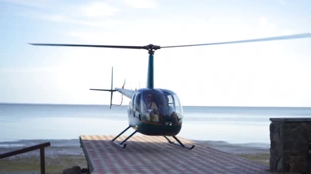 A helikopter felszáll a parton. A légi közlekedés kibontakozik és víz felett repül. Kiváló minőség. Mobil videó. 2020. szeptember 13. — Stock videók