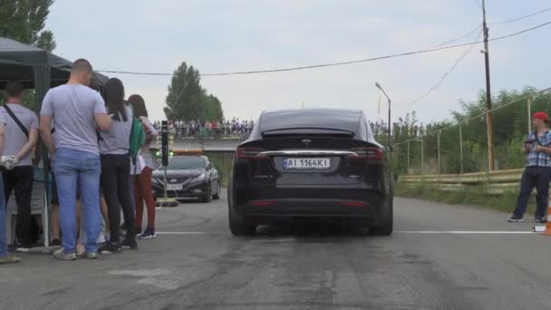 Versenyeznek a Tesla elektromos autóval. Az autó elkezd mozogni. Kiváló minőség. Augusztus 24, 2020 Kijev, Ukrajna — Stock videók