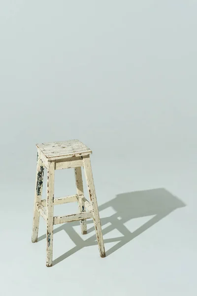Cadeira de madeira autêntica com tinta velha cor leiteira. Móveis brancos no fundo do estúdio de luz. Formato vertical. — Fotografia de Stock