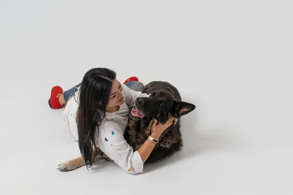 Brunette gelukkig vrouw met hond in fotostudio. — Stockfoto