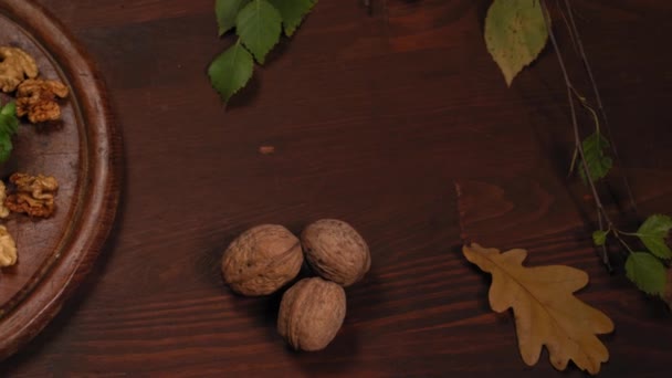 Autumn beautiful still life of walnuts, cheese, pears, grapes on a wooden texture board. View from above, top view. High quality 4k footage — Stock Video