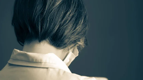 Femme médecin aux cheveux gris portant un masque et un manteau blanc. Gros plan. Vue arrière. Image en noir et blanc tonique — Photo