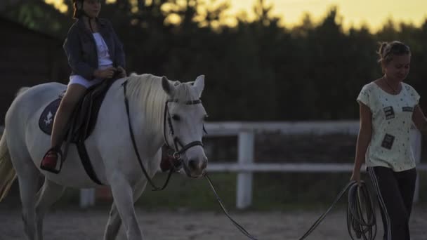 Apus de soare la fermă. Mersul pe cal. Fetiţa cu cască stă în şa. Hostess conduce Casa Albă. Kiev, Ucraina 29 august 2020. Igo-go Ranch . — Videoclip de stoc