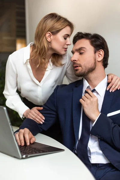 Szenvedélyes pár flörtöl az irodában. Az üzletember azt látja, hogy egy nő hátulról hozzáér, miközben a munkahely közelében áll. Csábító koncepció — Stock Fotó