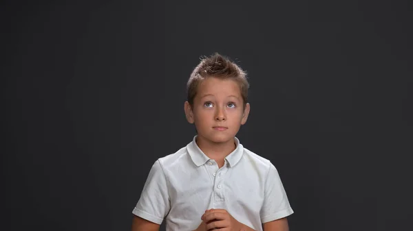 Tankeväckande eller väntande pojke vikta handflatorna tittar upp. Pensiv tonåring isolerad på grå bakgrund. Kopiera utrymme — Stockfoto