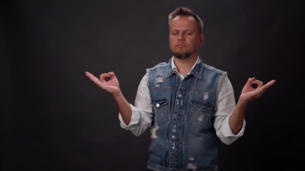 Mindfulness revealing stress man in denim vest falling asleep and falling on the floor. No stress man fell asleep standing in the studio isolated on black background. High definition footage — Stock Video