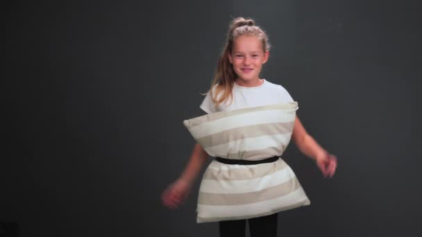 Moda almohada viral desafío moda tendencia para niña de 8-10 años posando en el estudio divirtiéndose aislado sobre fondo gris oscuro o negro. Imágenes de alta calidad. — Vídeo de stock
