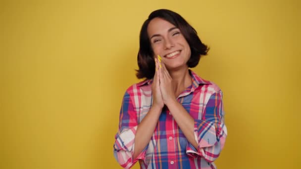 Charming woman expressing tenderness and saying good bye in plaid shirt on a yellow background. Facial expressions, emotions, feelings. High quality 4k footage — Stock Video