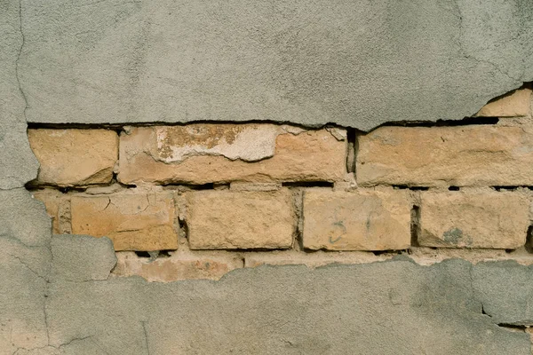 Υφή εξωτερικού τοίχου με πεσμένο σοβά. Παλιό κτίριο με πτώση από γύψο. Ιστορικό σχηματισμού πλίνθων τοίχων — Φωτογραφία Αρχείου