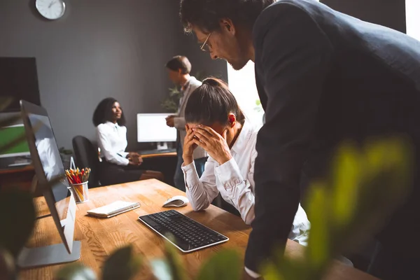 La niña lamenta el error cometido en el proyecto frente al mentor senior. Los empleados trabajan duro en el equipo para entregar el proyecto. Concepto de trabajo en equipo — Foto de Stock