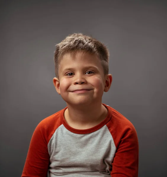 Kleiner Junge Kleinkind entzückende niedliche Porträt. Lächelnder kleiner Junge voller glücklicher Gefühle. Porträt, isoliert vor grauem Hintergrund. Gesichtsausdruck, Emotionen, Gefühle — Stockfoto