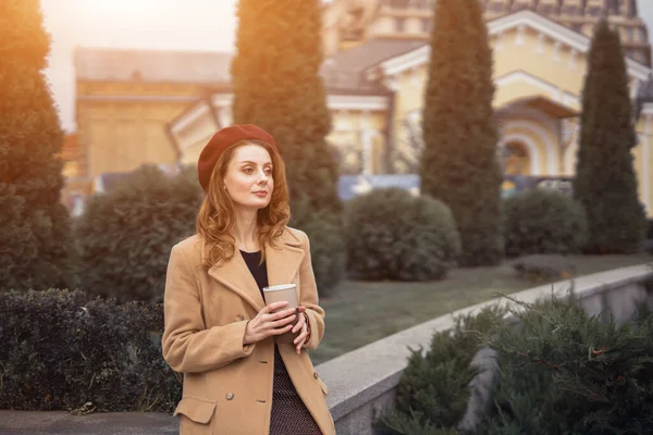 Pensif belle jeune femme tenant une tasse de café sur la mode féminine de la rue. Portrait d'une jeune femme élégante portant un manteau d'automne et un béret rouge à l'extérieur. Accessoires d'automne — Photo